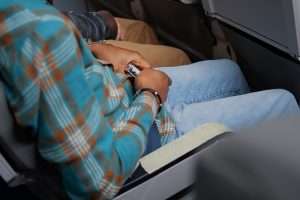 A passenger fastening their seatbelt for safety during airplane turbulence