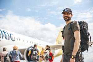 A man smiling about to board a flight