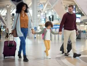 A family at the airport ready to travel with their suitcases